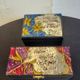 Boîte décorative avec citation en français, fleurs colorées et design élégant.