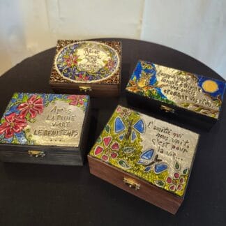 Boîtes décoratives avec citations et motifs colorés pour décoration.